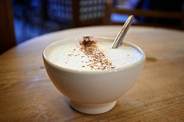 Xícara de café com leite cappucino na mesa de madeira de manhã