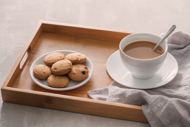 xícara de café com leite com biscoitos na luz de fundo de pedra