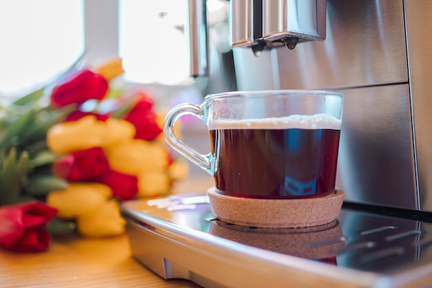 Xícara de café com leite e flores de tulipas em