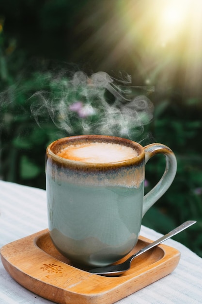 Xícara de café com leite em caneca de poesia verde em fundo de madeira velho ao sol da manhã