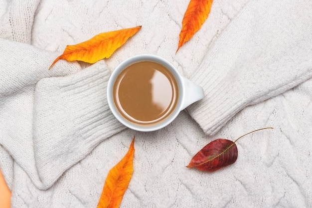 Xícara de café com leite lenço de malha branca deixa clima de outono composição de outono aconchegante