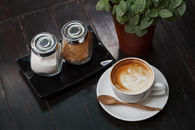 Xícara de café com leite na mesa de madeira