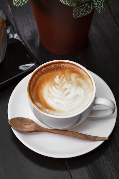 Xícara de café com leite na mesa de madeira
