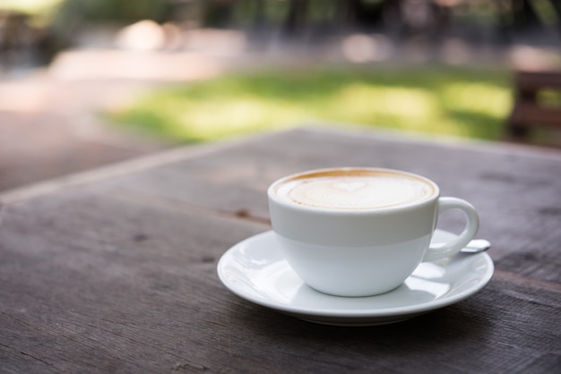 Xícara de café com leite na mesa de madeira