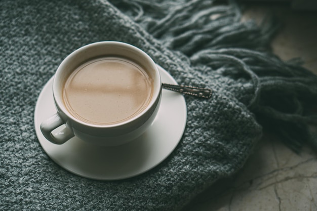 Xícara de café com leite no cobertor de inverno de malha aconchegante