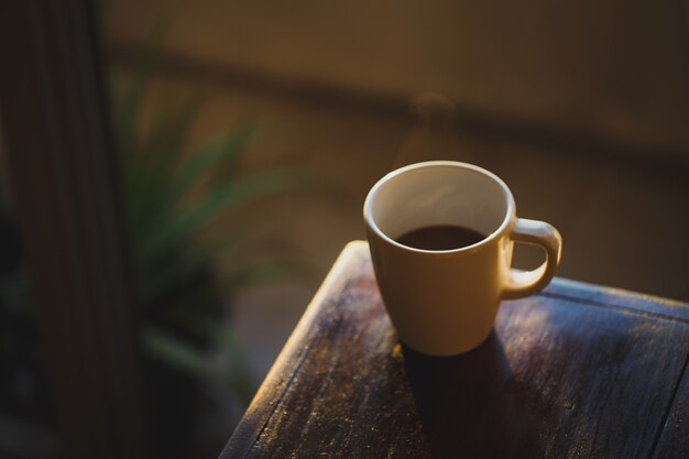 Xícara de café com luz e sombra em madeira velha, Manhã com café