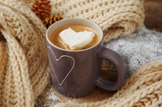 Xícara de café com marshmallow na mesa de madeira