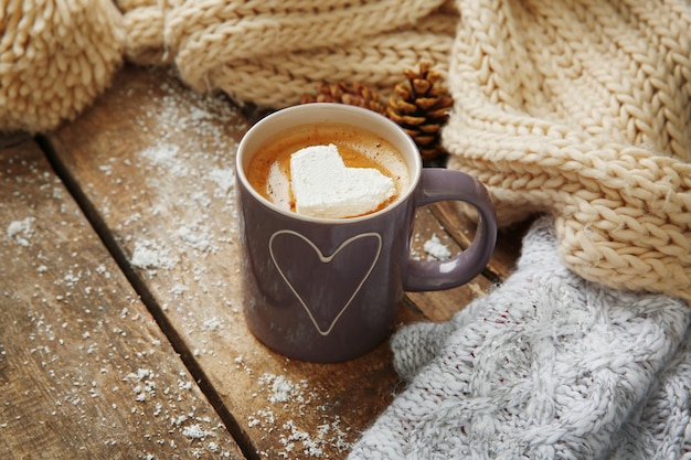 Xícara de café com marshmallow na mesa de madeira