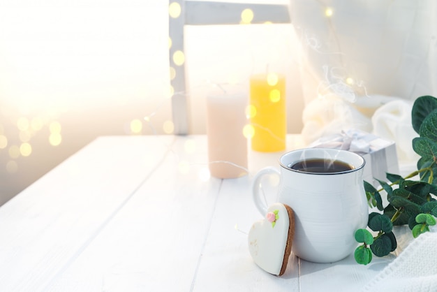 Xícara de café com o lenço feito malha em ficar na bandeja de madeira na cama, copie o espaço. Bom dia pequeno almoço