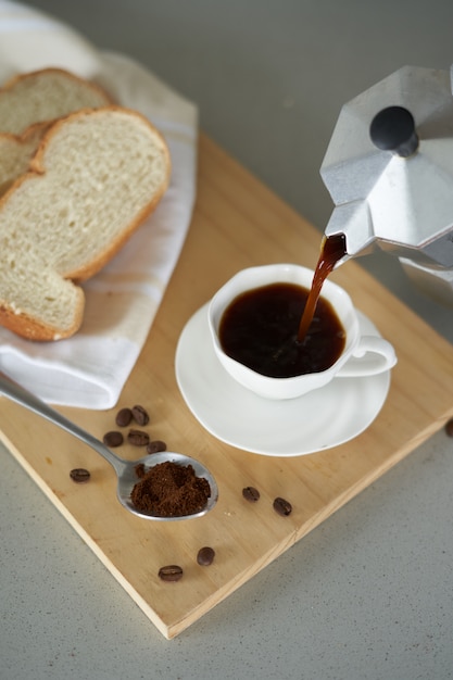 xícara de café com pão na mesa de madeira