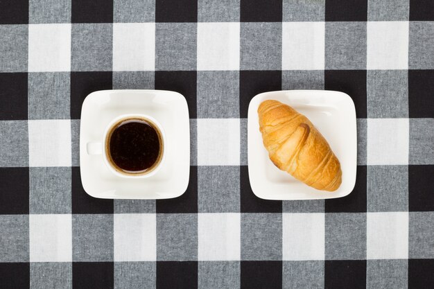 Xícara de café com pires e croissant