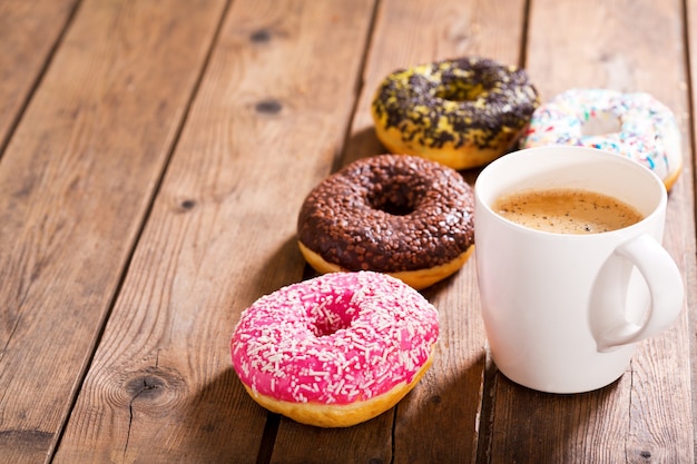 Xícara de café com rosquinhas na mesa de madeira