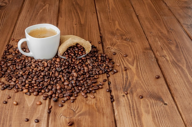 Xícara de café com saco de café na mesa de madeira. Ver de cima