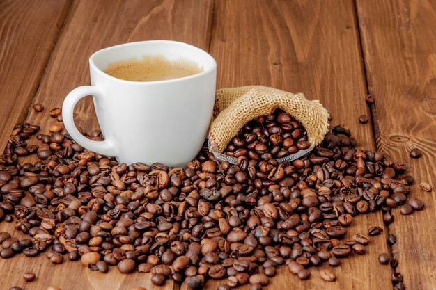 Xícara de café com saquinho de café na mesa de madeira