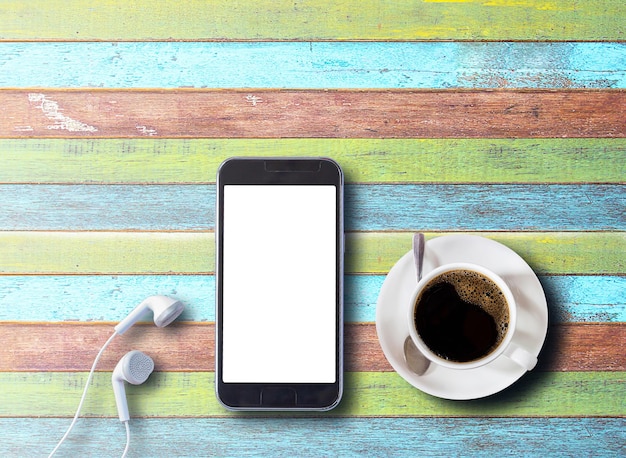 Xícara de café com smartphone e fones de ouvido