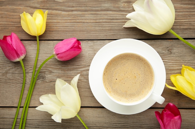 Xícara de café com tulipas na superfície cinza com espaço de cópia