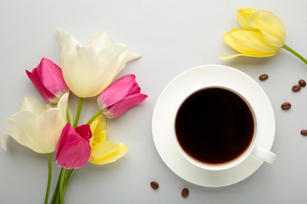 Xícara de café com tulipas na superfície cinza com espaço de cópia