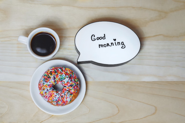 Foto xícara de café com um donut e um prato em um fundo de textura de madeira. conceito sobre o tema bom dia.