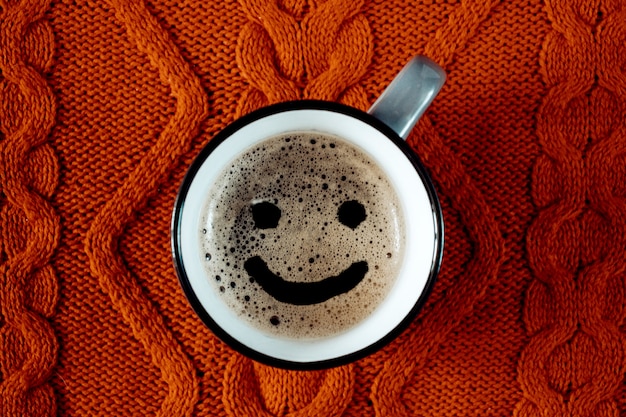 Xícara de café com um sorriso em uma malha