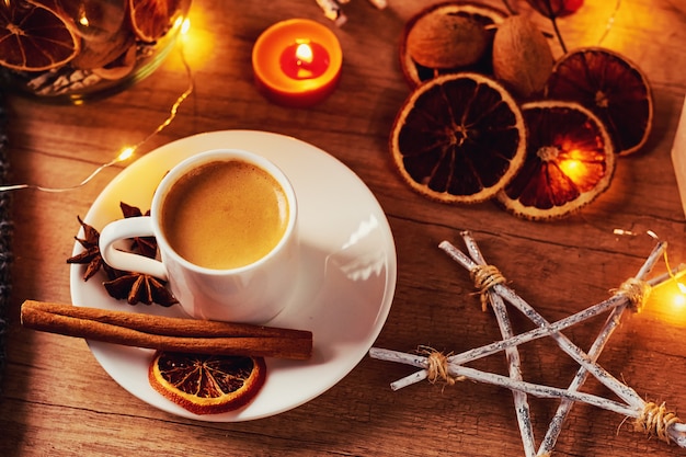 Xícara de café com uma decoração festiva e luzes de festão guirlanda