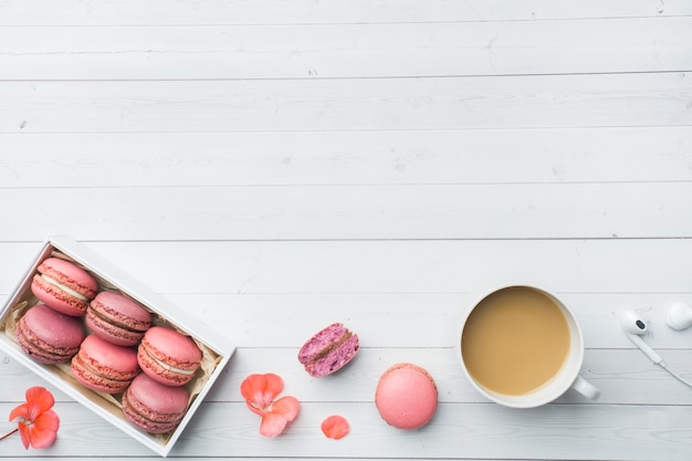 Xícara de café, cookies de biscoito em uma caixa, flores com lay plana