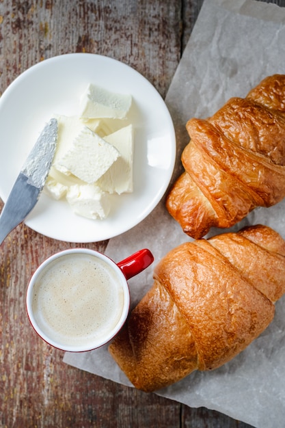 Xícara de café, croissants e manteiga