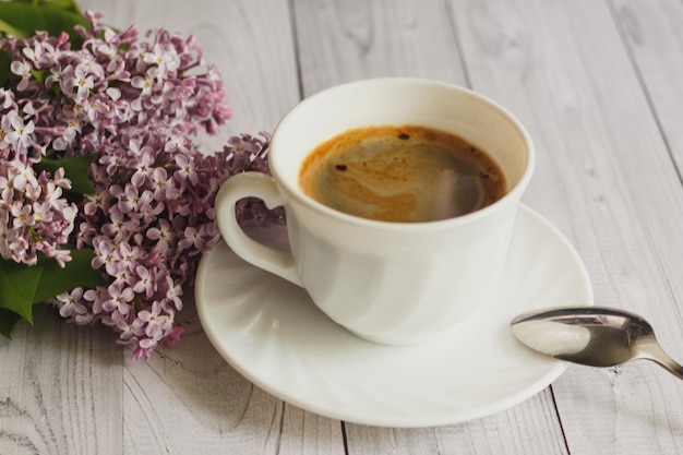 Xícara de café da manhã e flores lilás