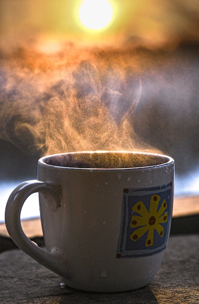 Xícara de café da manhã no terraço de inverno com o sol nascente como pano de fundo