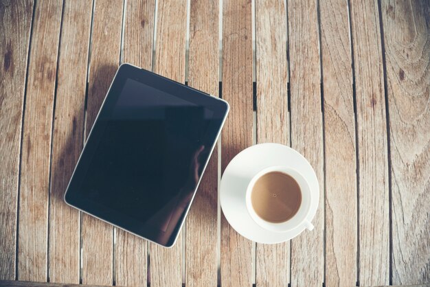 Xícara de café de laptop de mesa para oficial exibir o espaço vazio no fundo de madeira