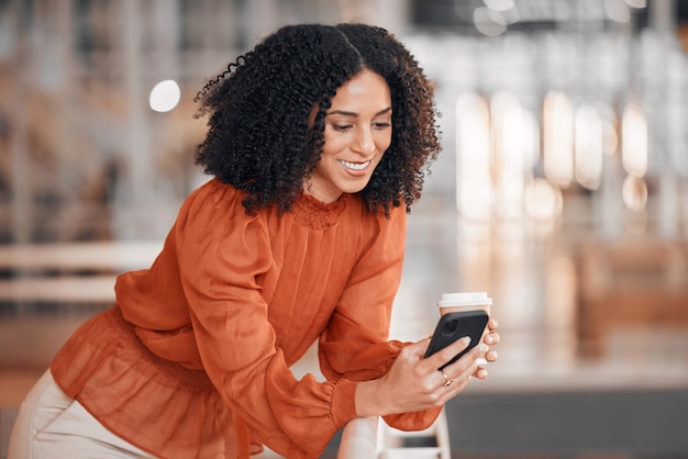 Xícara de café de mulher de negócios e digitando com telefone para site móvel de rede social e contato digital Trabalhador feliz bebendo e enviando mensagens de texto na tecnologia de smartphone enquanto lê notificação de aplicativo no escritório