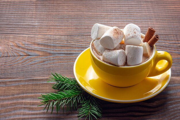 Xícara de café de Natal com marshmallows em fundo de madeira