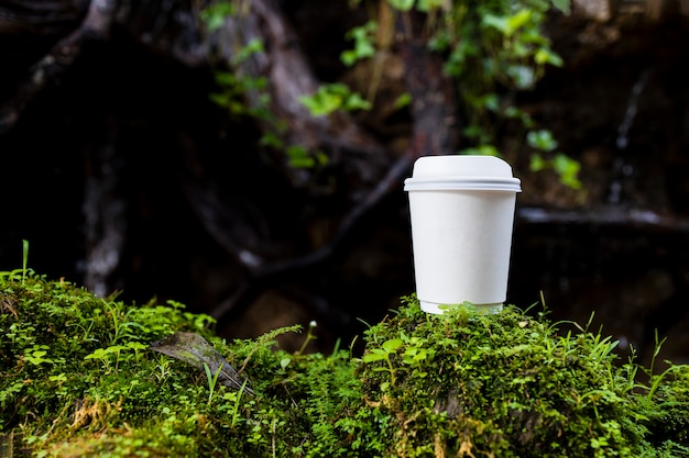 xícara de café de papel branco na bela natureza