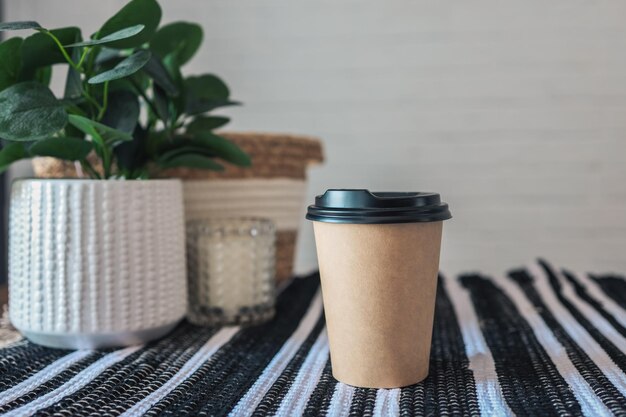 Xícara de café de papel na mesa de café em estilo escandinavo