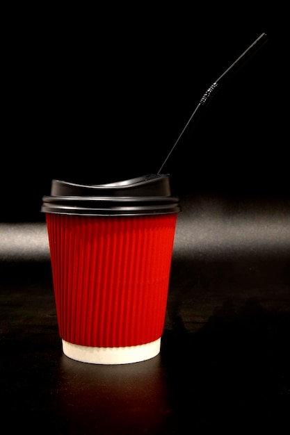 Xícara de café de papel vermelho com um tubo.