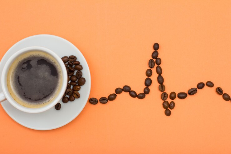 Foto xícara de café de porcelana branca em pires com grãos de café dobrados na forma de um eletrocardiograma sobre fundo cor de pêssego. vista do topo