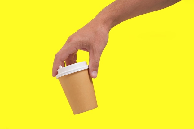 Xícara de café descartáveis em fundo amarelo mão. Café para levar.