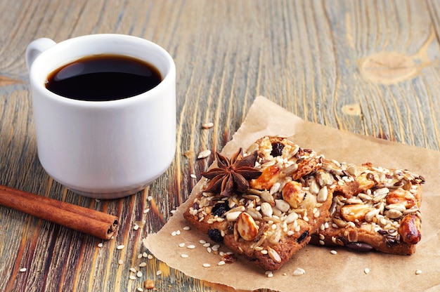 Xícara de café e biscoitos com nozes na velha mesa de madeira