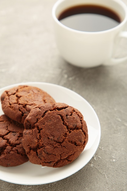 Foto xícara de café e biscoitos de chocolate em fundo cinza