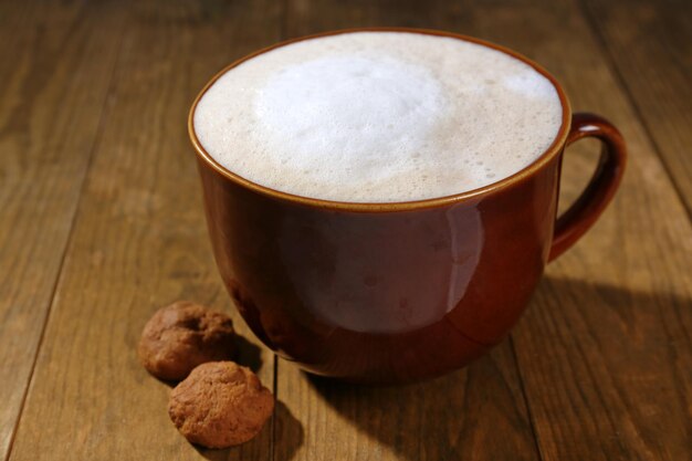 Xícara de café e biscoitos em fundo de madeira