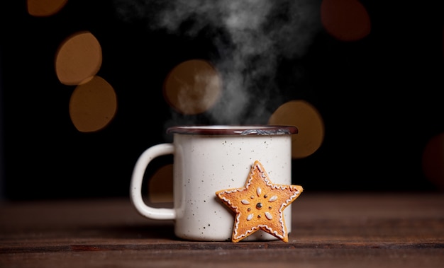 Xícara de café e biscoitos em uma mesa com luzes de fada