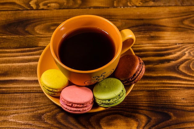 Xícara de café e biscoitos franceses na mesa de madeira