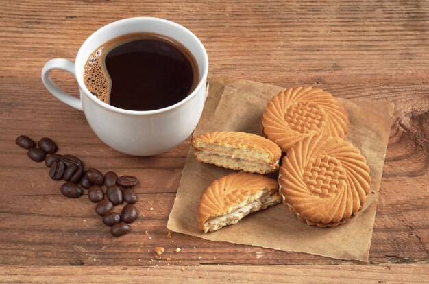 Xícara de café e biscoitos saborosos com recheio de creme