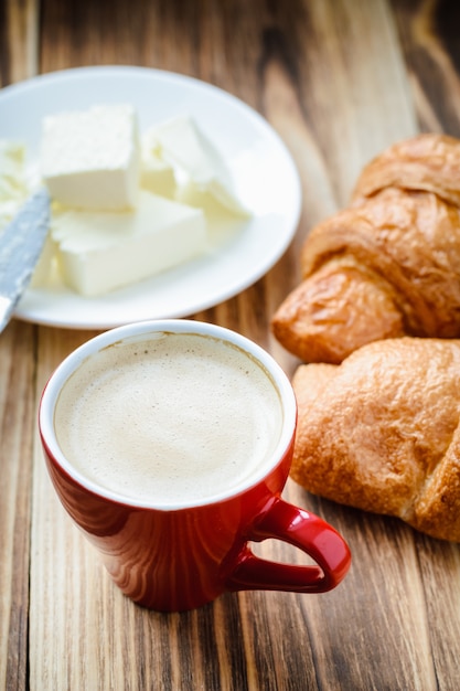 Xícara de café e croissants com manteiga