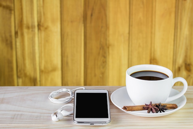 Xícara de café e estacionária no conceito de mesa de escritório de mesa de madeira