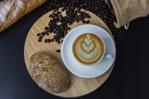 Foto xícara de café e feijão branco sobre fundo preto