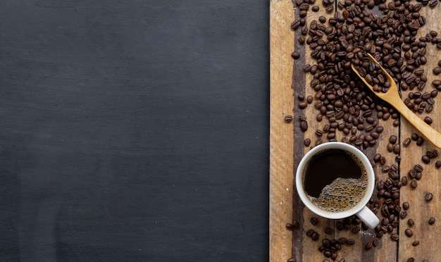 Xícara de café e feijão na mesa de madeira