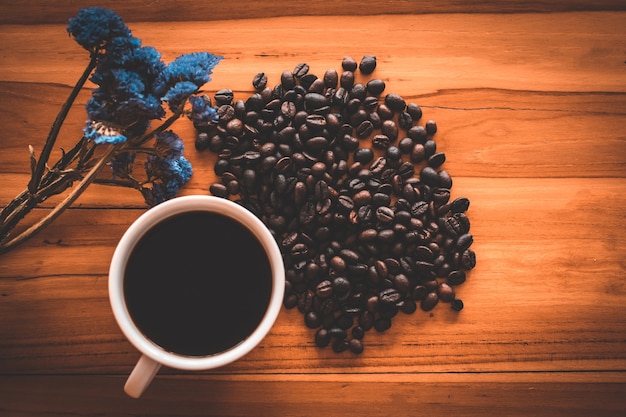 Xícara de café e feijão na velha mesa da cozinha