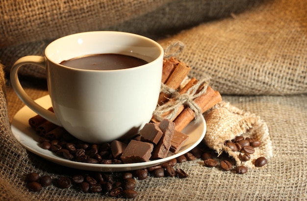 Xícara de café e feijão, paus de canela e chocolate sobre fundo de demissão