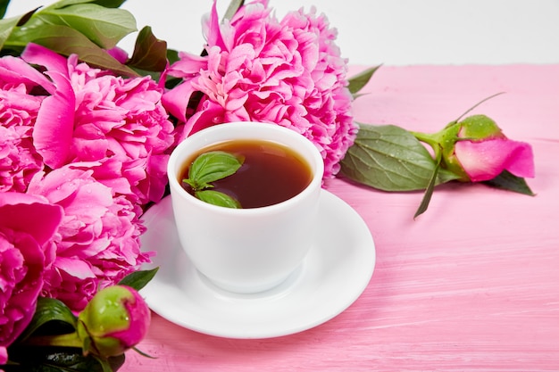 Xícara de café e flores de peônia buquê
