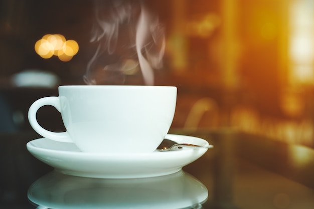Foto xícara de café e fumaça na mesa no café.